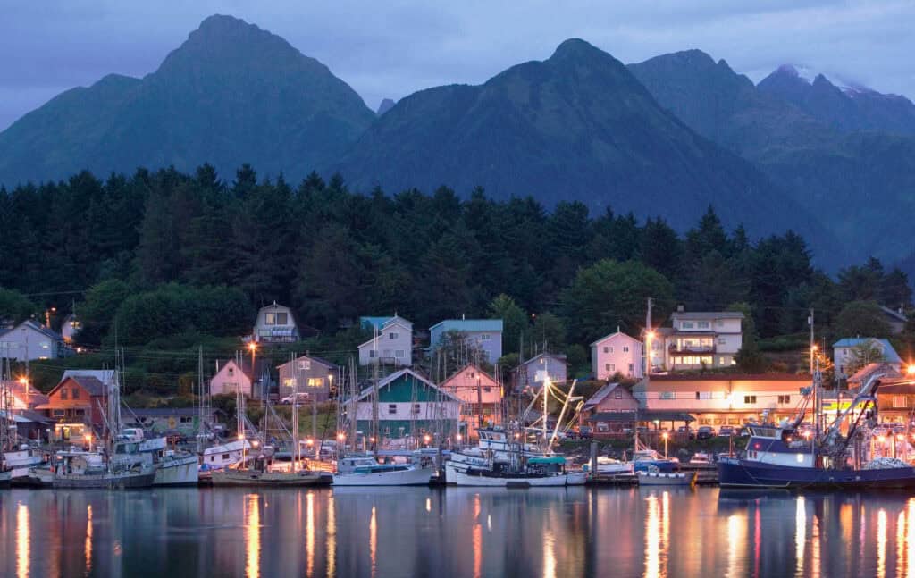 A harbor with boats and houses in the background.